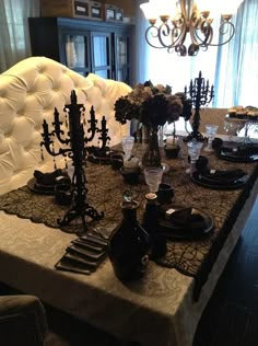 an image of a dining room table set up for halloween dinner with black and white decorations