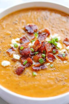 a white bowl filled with soup and topped with bacon