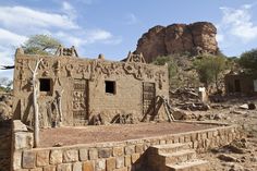 an adobe style building in the desert with mountains in the background