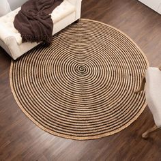 a living room with wooden floors and a round rug on the floor next to a chair