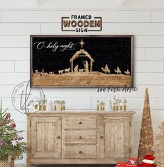 a wooden sideboard with christmas decorations on it and a framed sign above it that reads, merry night