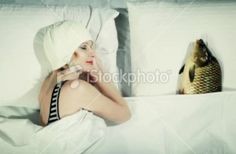 a woman laying in bed next to a fish