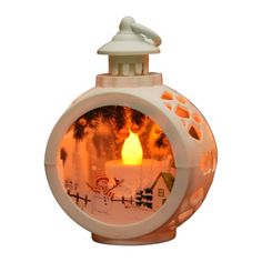 a small white candle with a snowman on the front and santa's house in the back