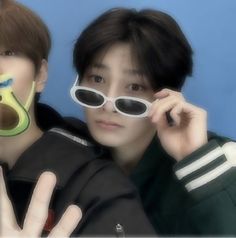 two young men with fake sunglasses on their faces and one holding up the peace sign