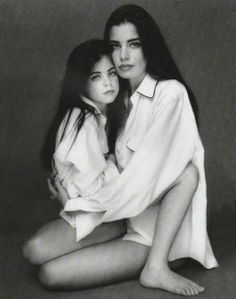 black and white photograph of two women sitting next to each other with their arms around one another