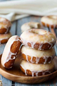 glazed doughnuts stacked on top of each other in a wooden bowl with white icing