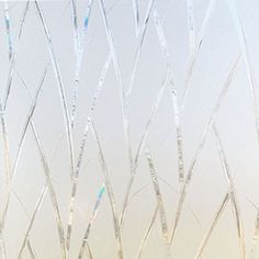 a window with frosted branches on it and a vase in the foreground holding flowers