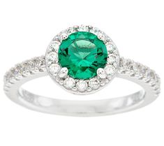 an emerald and diamond ring with white diamonds on the band, set in 18k white gold