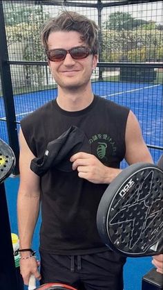 a man holding two tennis racquets in his hands