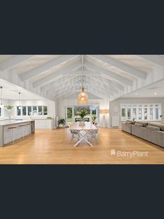 a large open living room with white walls and wood flooring on the wooden floors