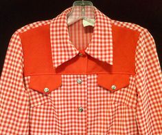 This is a vintage 60's or 70's, woman's size 12, red gingham, country western blouse.  There is no makers label, but it is made in USA of 100% thick polyester.  It is a red, check, western style shirt with contrasting, solid, red trim on the collar, chest and cuffs.  There are 2 faux, breast pockets with flaps.  There are silver tone, metal buttons on the front closure, pockets and cuffs.  This could be worn buttoned or unbuttoned as an over-shirt and would be great if you are into square dancing.  It is in very good condition with no stains, snags of rips.  Please go by the measurements provided to insure proper fit as this item is not returnable. Shoulder:  14 inches Chest:  37 inches Hips:  40 inches Length:  26 inches Sleeves:  22 inches Vintage Plaid Tops With Snap Buttons, Vintage Collared Tops For Rodeo, Retro Collared Tops For Rodeo, Retro Fitted Gingham Tops, Retro Plaid Tops With Buttons, Vintage Red Tops For Rodeo, Retro Fall Tops With Snap Buttons, Retro Gingham Tops With Button Closure, Retro Gingham Top With Button Closure