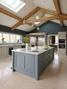 a large kitchen with an island in the middle and skylights above it on the ceiling