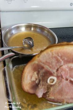 the ham is being cooked on the stove with a pot of soup in front of it