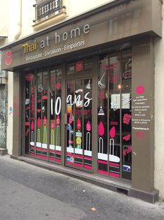 a store front with pink and green decorations on the windows