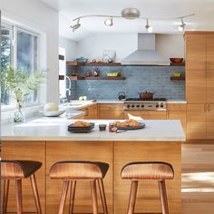 a kitchen with wooden cabinets and stools