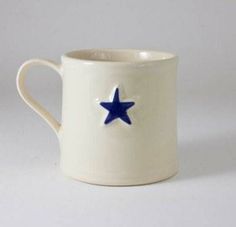 a white coffee cup with a blue star on it