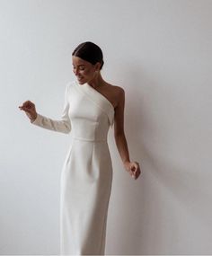 a woman in a white dress posing for the camera with her hand on her hip