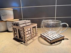 a cup and coasters sitting on a counter top