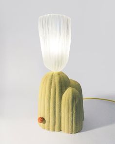 a green cactus lamp with a white light on it