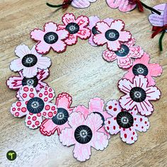 the paper flowers are laid out on the wooden table to be made into a wreath