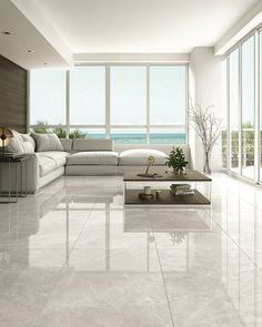 a living room with white furniture and large windows overlooking the ocean on a sunny day