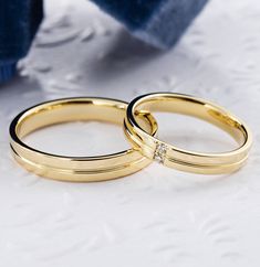 two gold wedding rings with diamonds on them