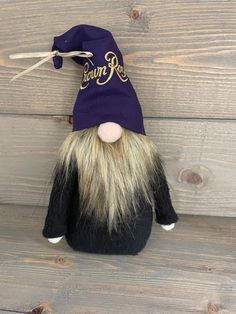 a stuffed animal with a purple hat on it's head and long white hair