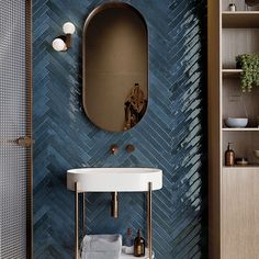 a bathroom with blue tiles and gold fixtures on the wall, along with a round sink