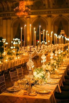 a long table is set up with candles and place settings for an elegant wedding reception