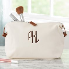 Embroidered with any name, initial or monogram in a choice of thread color and fontChoose from 3 cosmetic bag colors Holds various items while travelingExterior constructed of vegan leatherBlack/grey stripe poly/cotton liningInterior pocketZipper closure on top of bagSide snap closuresWipe cleanMeasures 13" L x 4" W x 7.5" HImported Keep all your important necessities secure in our trendy Personalized Vegan Leather Cosmetic Travel Case! This custom embroidered cosmetic bag will ha Leather Monogram Bags For Travel, Monogram Leather Bags For Everyday Use, Customizable Leather Travel Bags, Personalized Brown Leather Bag, Leather Monogram Bag For Everyday Use, Everyday Leather Bag With Monogram, Leather Makeup Pouch, Monogrammed Makeup Bags, Custom Makeup Bags