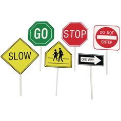 several street signs are shown on sticks with stickers in the shape of stop, slow and do not enter