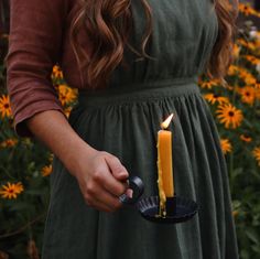 a woman holding a lit candle in her hand