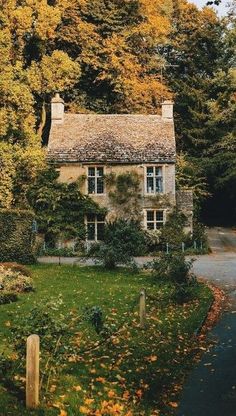 an old house surrounded by trees in the fall