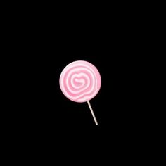 a pink lollipop on a black background