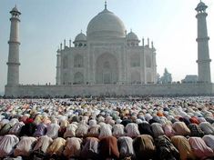 a large group of people standing in front of a building with many minalis on it