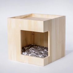 a small wooden box with a cushion inside