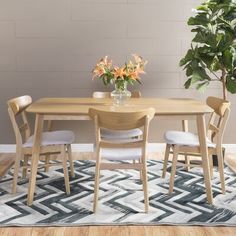 a wooden table with four chairs and a potted plant on top of the table