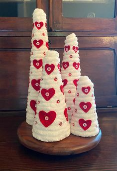 three white christmas trees with red hearts on them