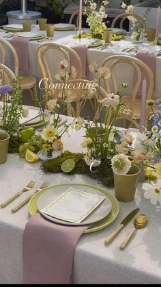 the table is set with flowers and place settings