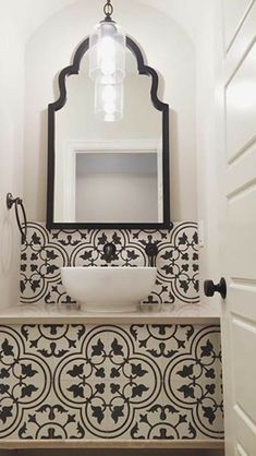 a white sink sitting under a bathroom mirror next to a wall mounted faucet