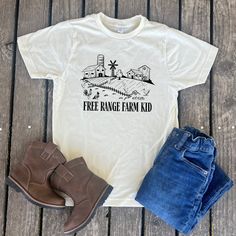 Celebrate the joy of farm life with our "Free Range Farm Kid" Toddler and Youth Shirt! Perfect for little ones who love the countryside, this cute country shirt features an adorable design inspired by free-range chickens. Whether they're a farmer's son or daughter, this shirt is an ideal addition to any young farm enthusiast's wardrobe. ---Shirt Color--- This shirt comes in the colors shown above. ---Care Instructions--- Turn inside out. Machine wash cold. Air dry if possible otherwise dry on low heat. Do not use liquid fabric softener. Do not bleach or iron on design. ---Additional Info--- If interested in a shirt/word color not listed send us a message and we can talk about different options! Or if you have any other questions regarding a variation of this piece don't hesitate to reach o Country Style Pre-shrunk Cotton T-shirt, Country Style Cotton Pre-shrunk T-shirt, Country Style Cotton T-shirt, Country Style Relaxed Fit Cotton T-shirt, Country Style Cotton T-shirt With Short Sleeves, Country Style Cotton Tops With Relaxed Fit, Country Style White Cotton T-shirt, Country Style Short Sleeve Cotton Tops, Cute Country