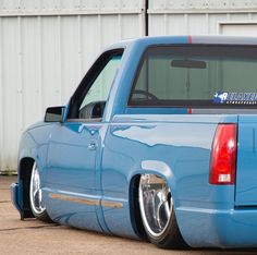 a blue pick up truck parked in front of a building