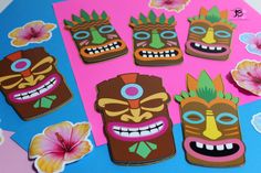 several tiki masks are shown on a pink and blue background