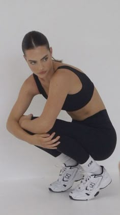 a woman squatting down with her legs crossed