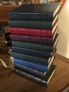 a stack of books sitting on top of a wooden table