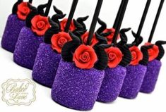 there are many purple and red candles with roses on them