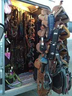 a horse trailer filled with lots of different types of saddles and bridles