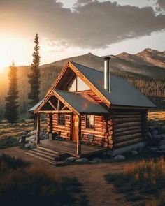 a log cabin sits in the mountains at sunset