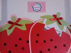 two strawberry shaped magnets with bows on them