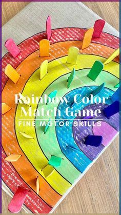 the rainbow color match game for fine motor skills is shown in front of a wooden table